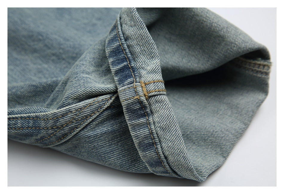 Close-up of a folded light blue denim hem showing the inner fabric and reinforced stitching.