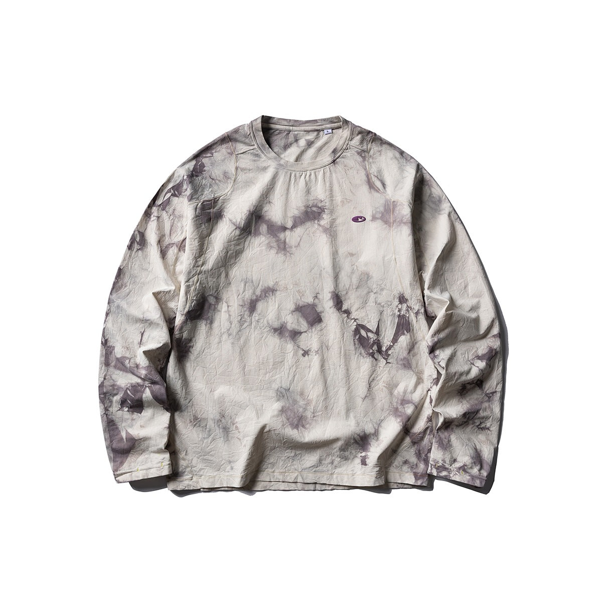 Gray-purple tie-dye long-sleeve crew-neck top flat lay with a small purple oval chest patch