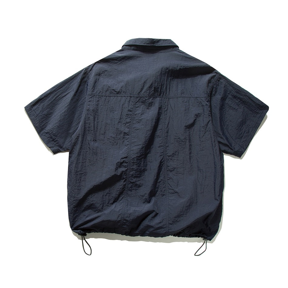Back view of navy short-sleeve shirt with back yoke seam, panel seams and drawstring hem