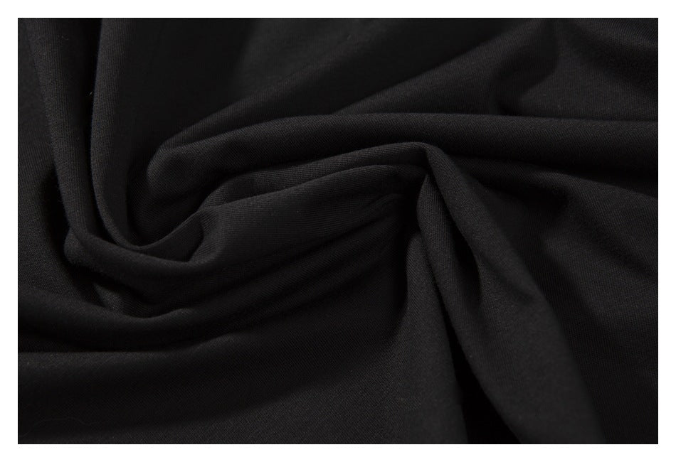 Close-up of black fabric gathered into folds, showing its surface and drape.