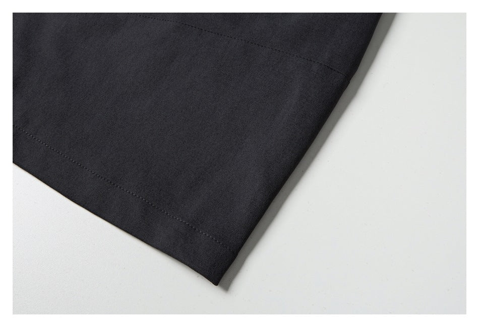 Close-up of a charcoal trouser leg showing the stitched hem.