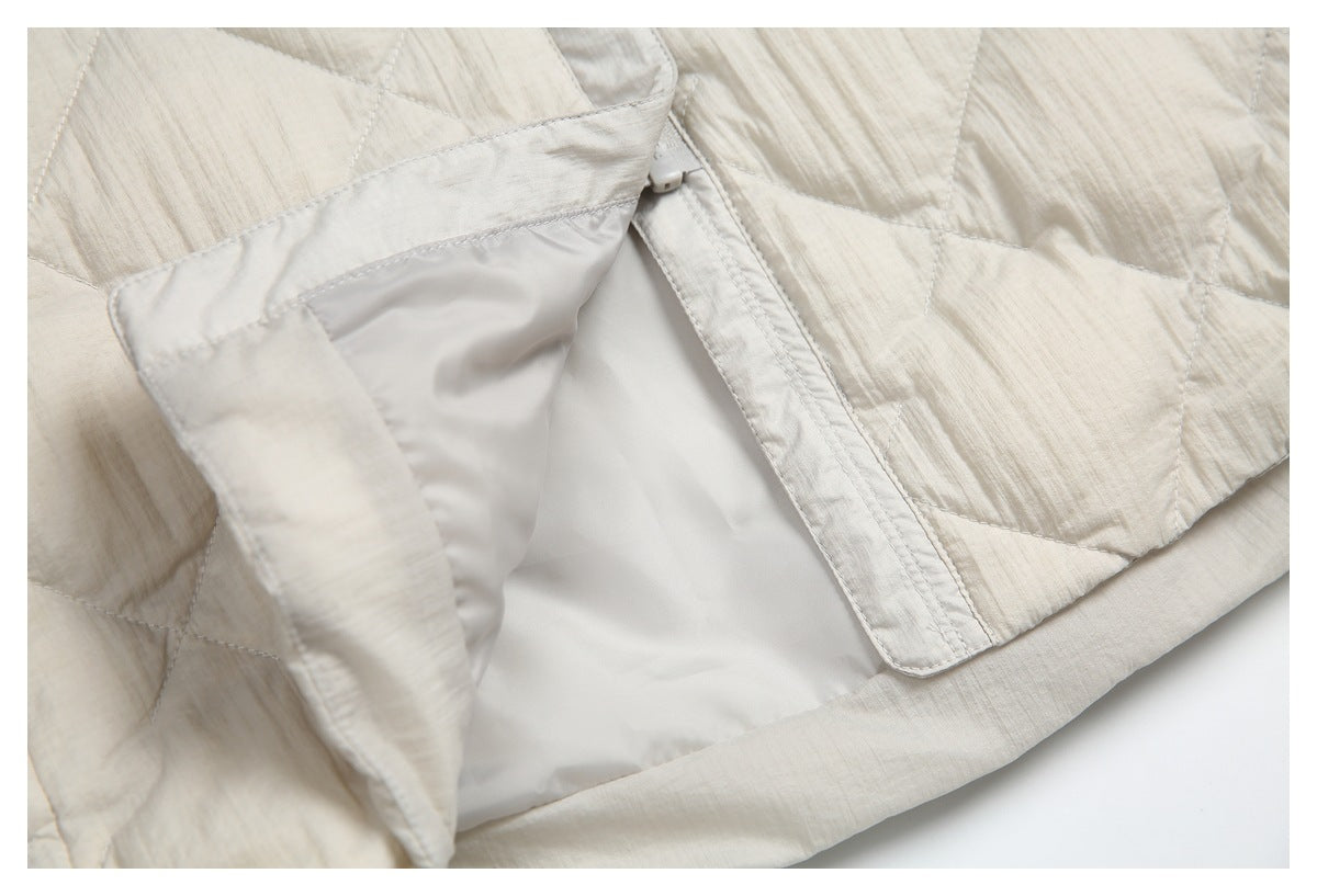 Close-up showing the cream jacket's front placket, pale lining, and quilted exterior.