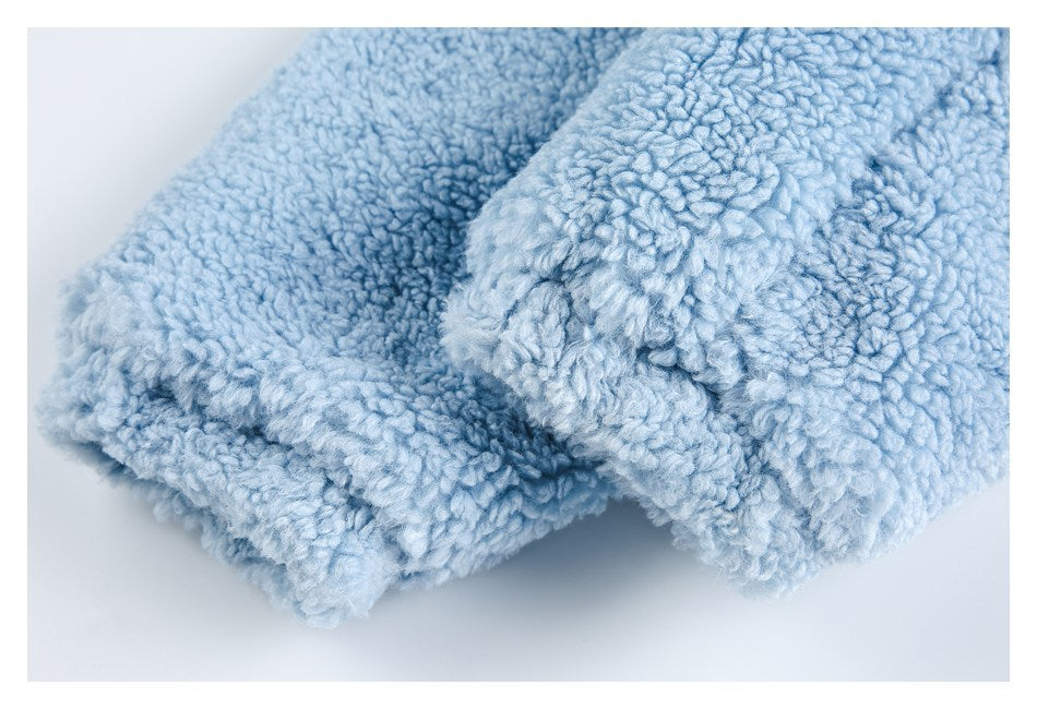 Close-up of the thick, fluffy light blue fabric folded to show its plush edge.