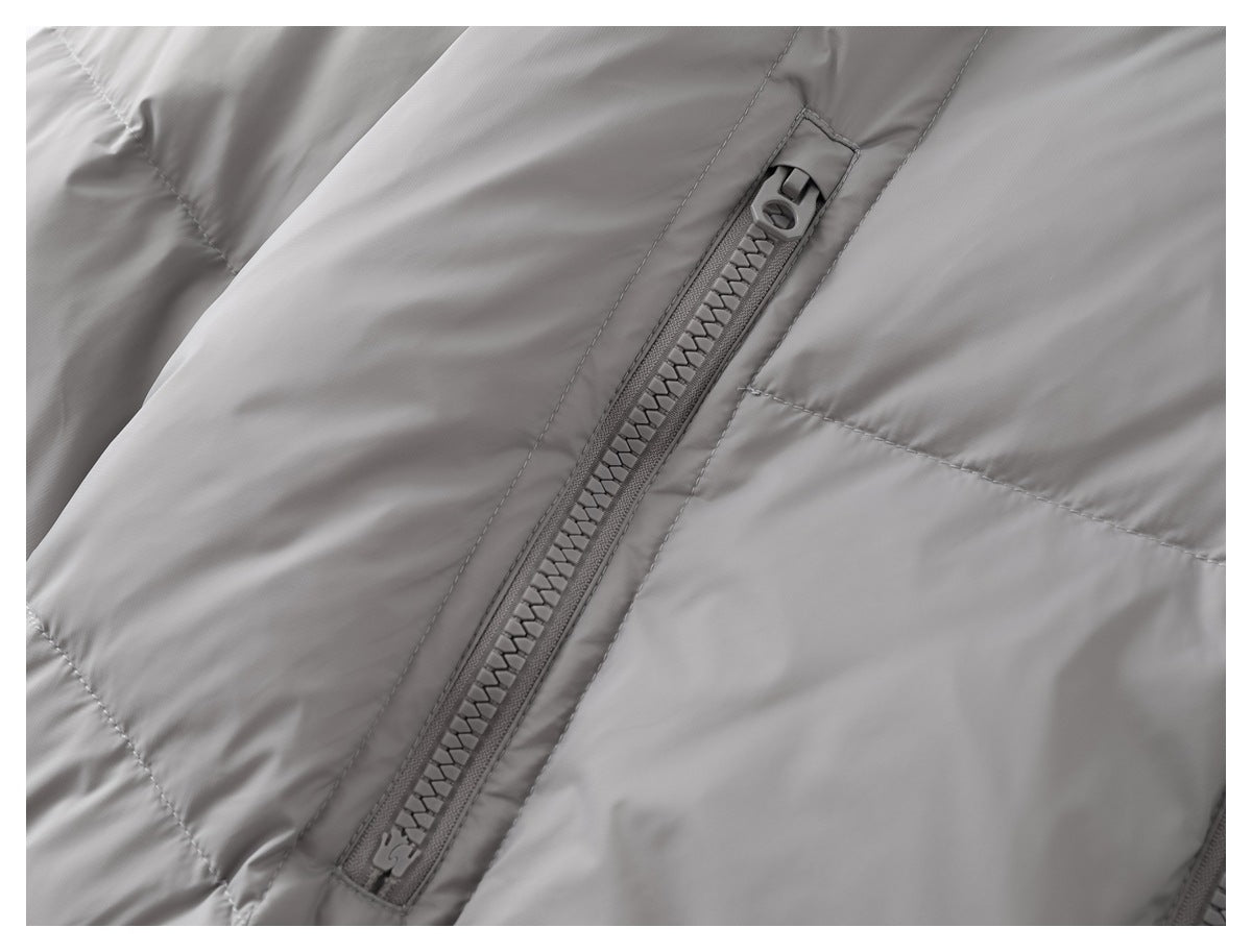 Close-up of a diagonal zip pocket on a gray padded jacket.