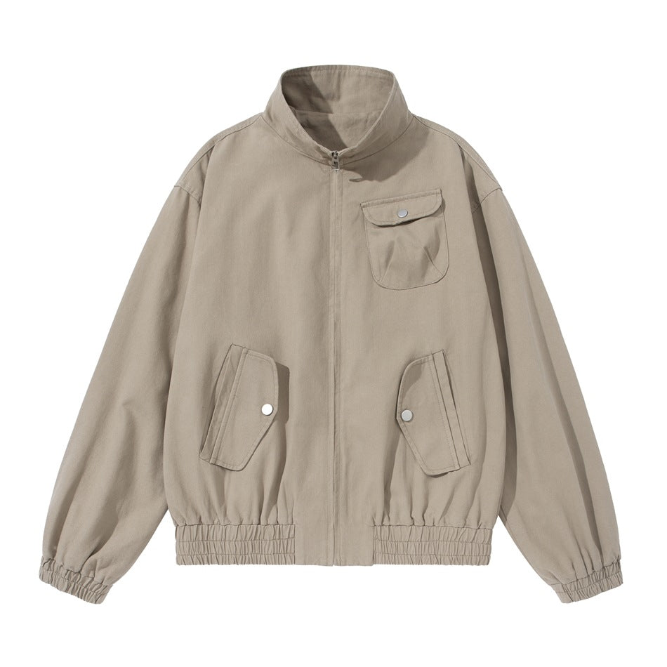 Light khaki zip-front jacket with stand collar, snap-flap chest and lower pockets, and elastic cuffs and hem, flat lay
