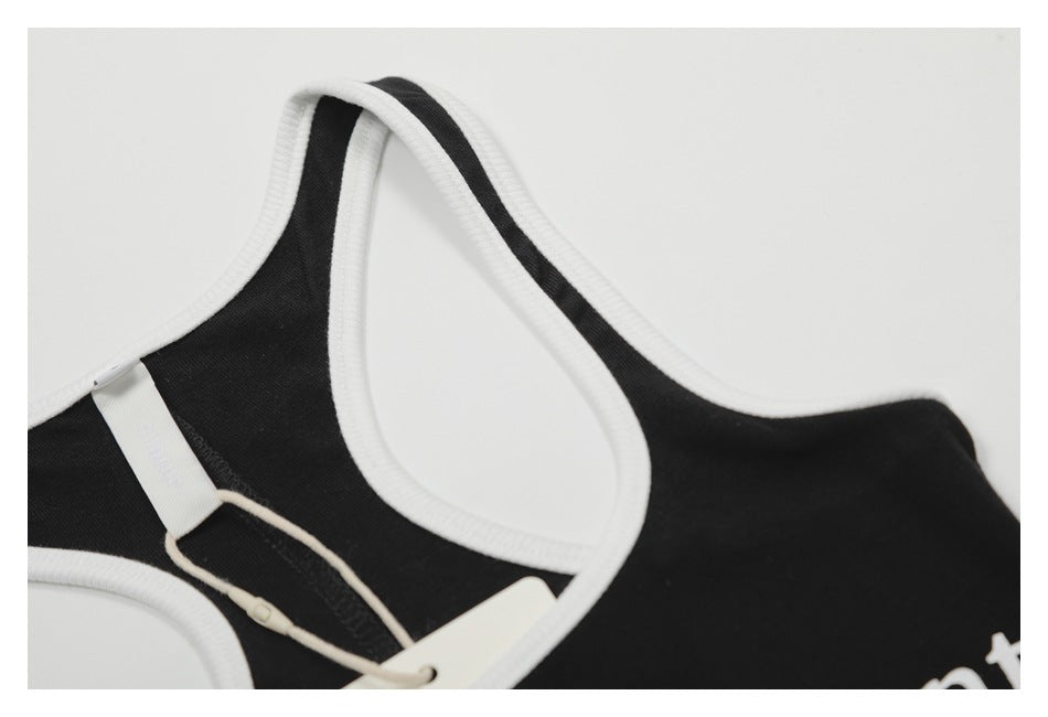 Close-up of the black tank top's white-trimmed racerback neckline and attached hang tag.