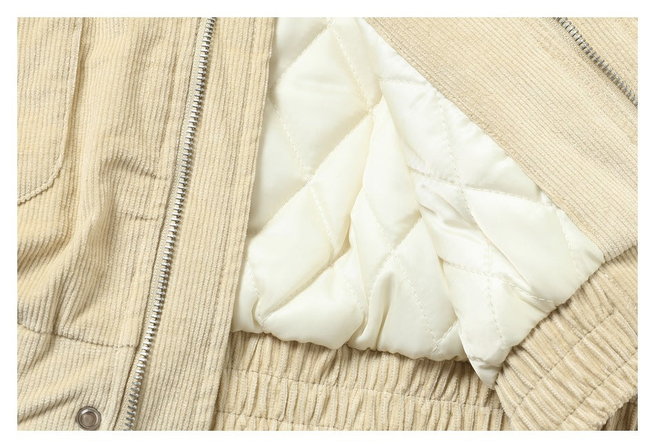 The cream corduroy jacket is opened to show its light diamond-quilted lining and front zipper.