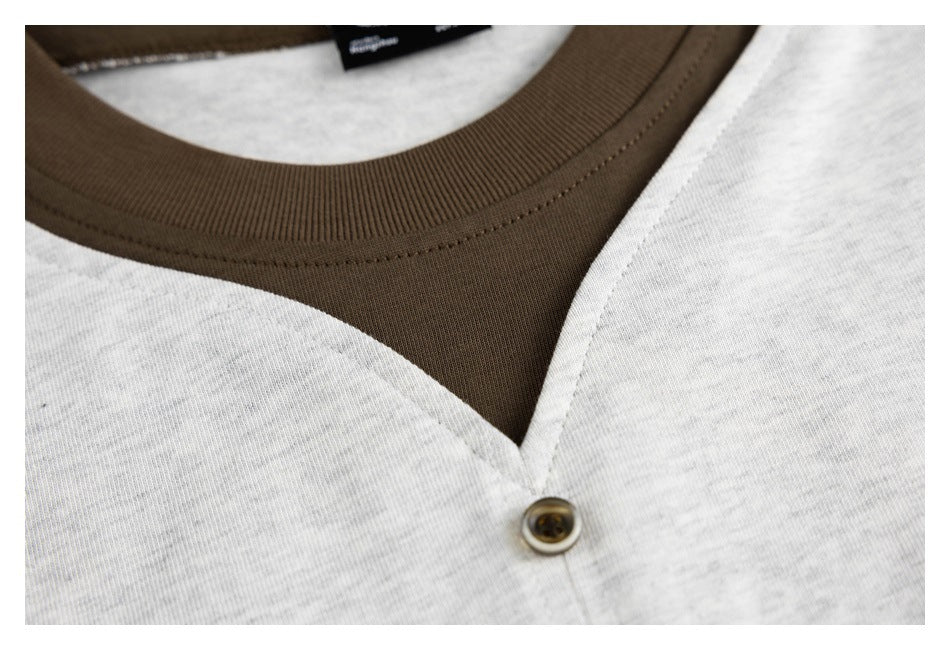 Close-up of the light gray shirt's dark brown ribbed collar and contrasting V-shaped neckline.