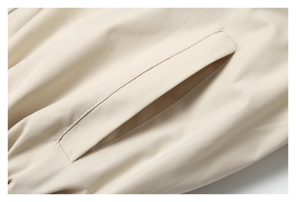 Close-up of a long welt pocket on cream jacket fabric.