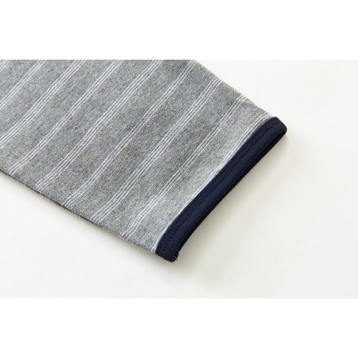 Close-up of a gray striped sleeve ending in a dark navy ribbed cuff.