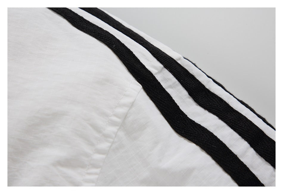 Close-up of two black stripes along a white jacket shoulder.