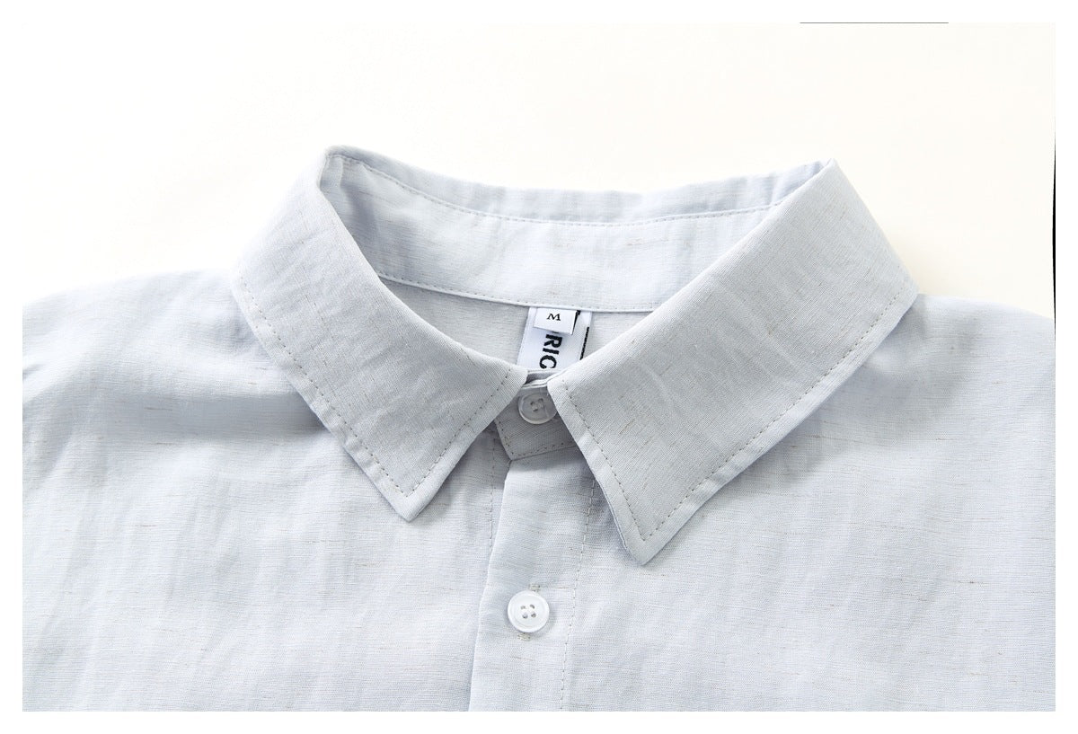 Close-up of a pale blue-gray button-down shirt collar, top button, and placket.
