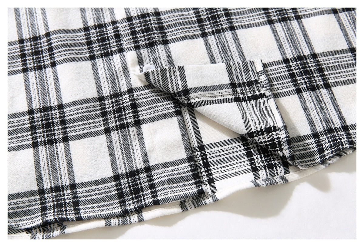 Close-up of the lower hem and a folded section of the black-and-white plaid shirt.