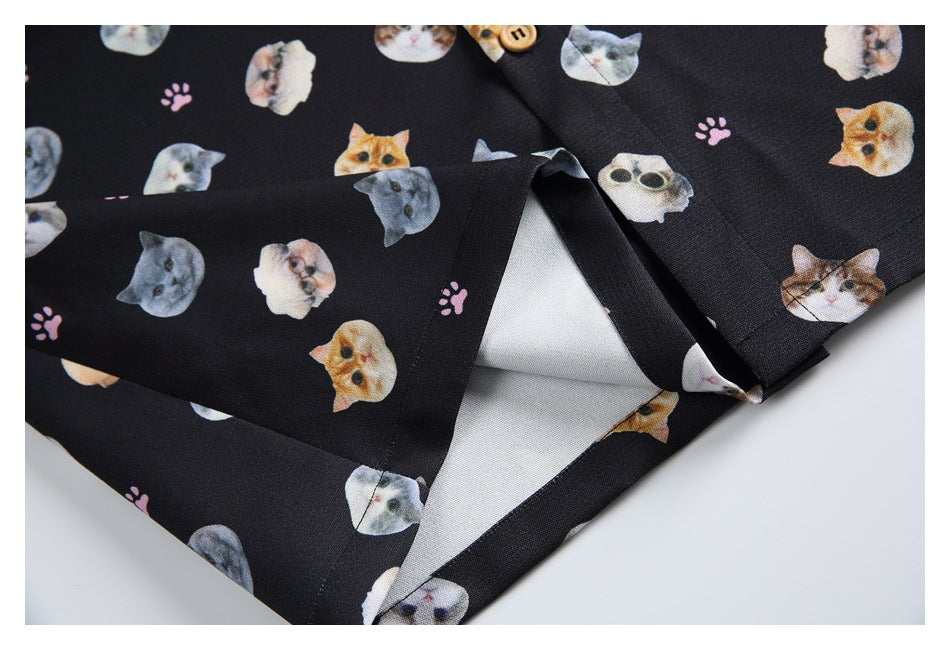 Close-up of the hem and side opening on a black cat-print shirt.
