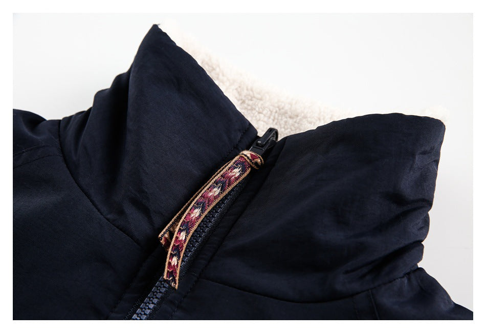Close-up of a black jacket hood and zipper with a patterned fabric zipper pull.