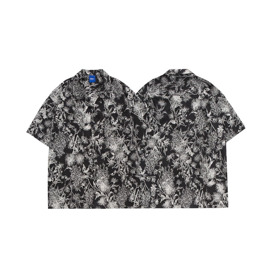 Front and back flat views of a black short-sleeve shirt covered in a dense white botanical print.