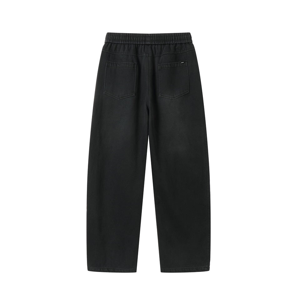 Back view of black elastic-waist pants with two patch pockets and faded finish