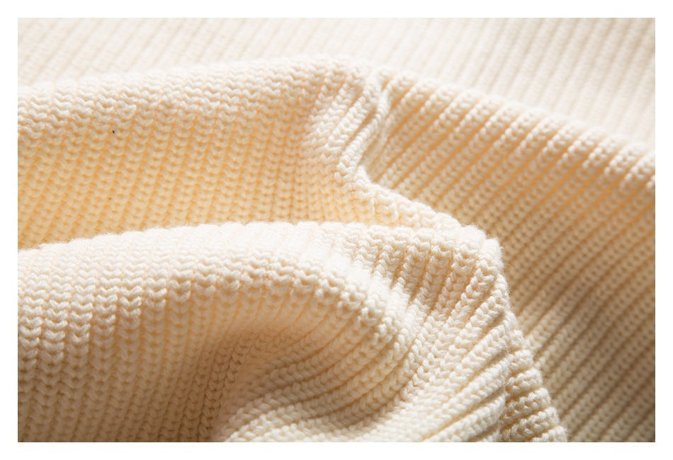 Ivory knit fabric folded to show its textured stitches and ribbed section.