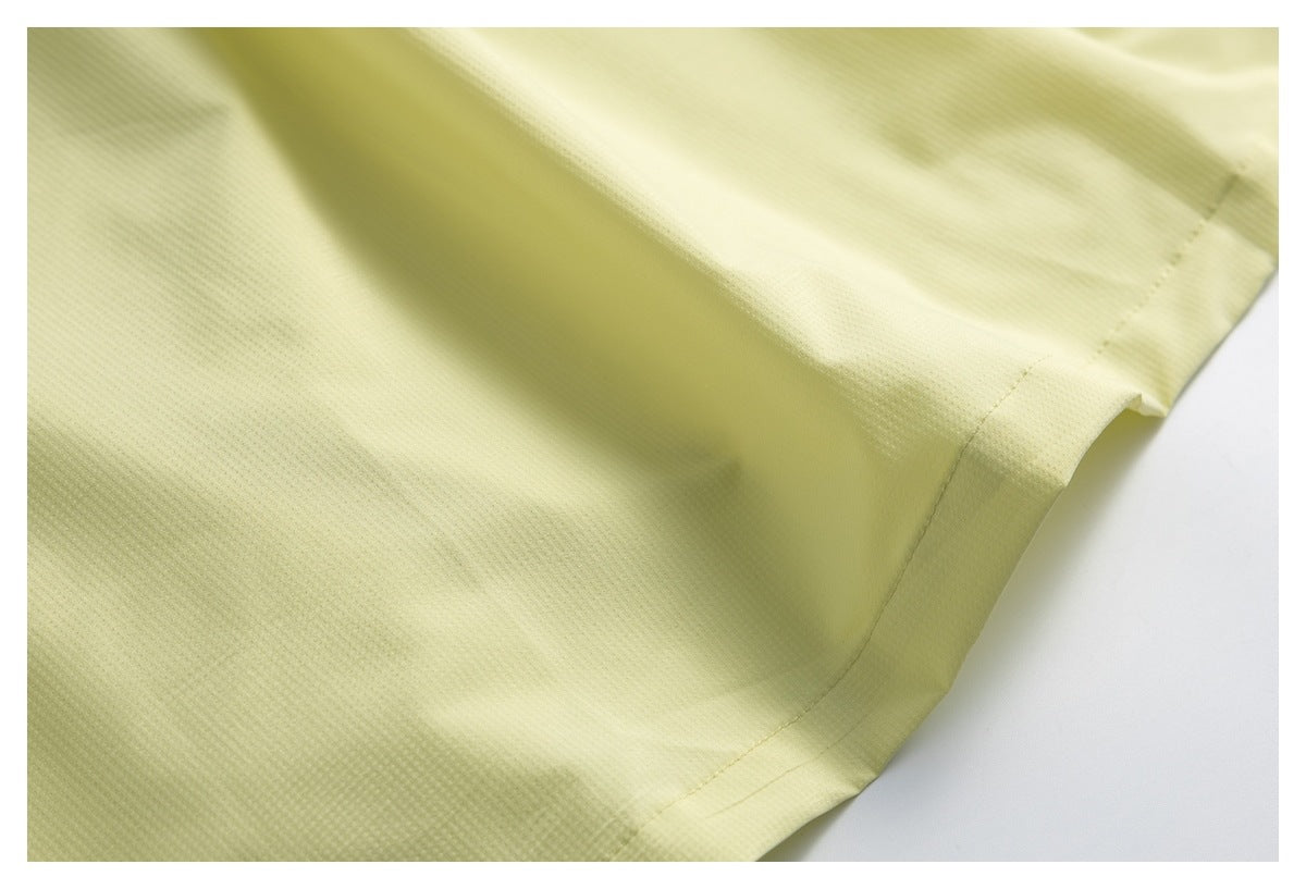 Close-up of pale yellow garment fabric and stitched hem.
