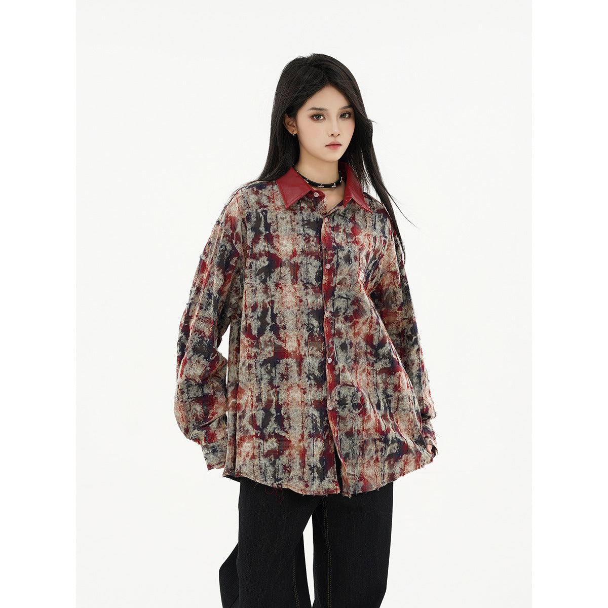 Model wearing an oversized charcoal, red and cream abstract-print button-up shirt with a dark red collar.