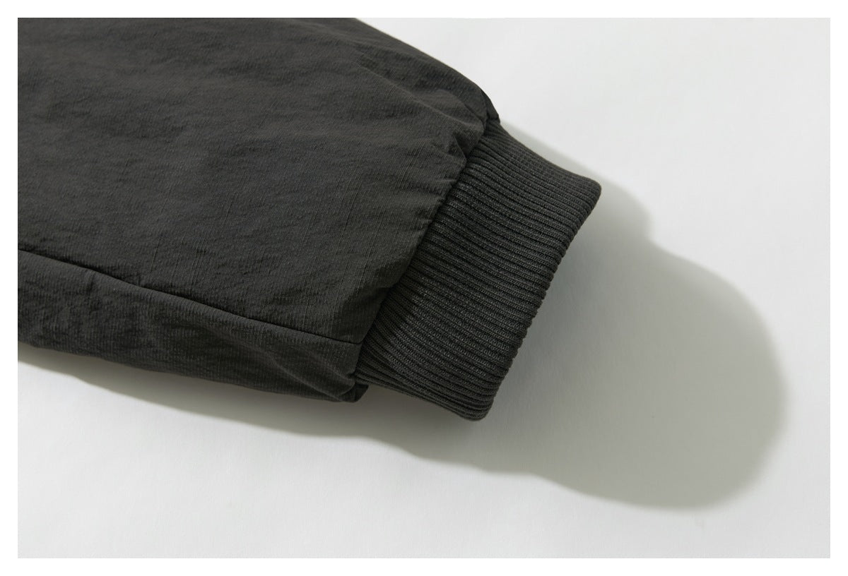 Close-up of a dark charcoal sleeve ending in a wide ribbed cuff against a white background.