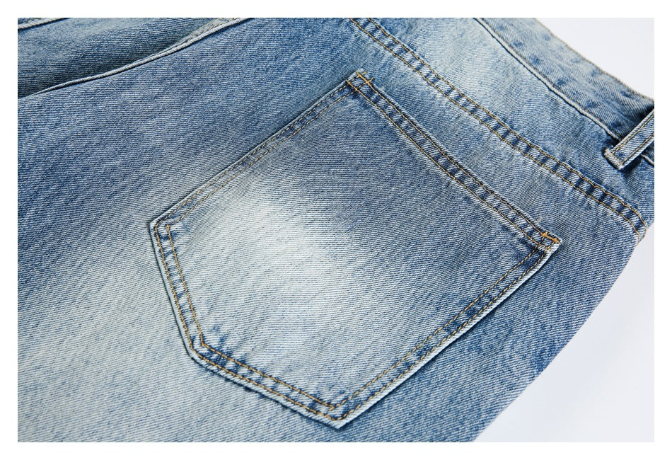 Close-up of a light blue faded jeans back pocket with contrast stitching and a belt loop.
