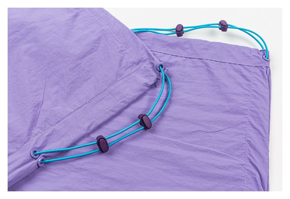 Close-up of lavender pants with turquoise adjustable cords and purple toggles along the side.