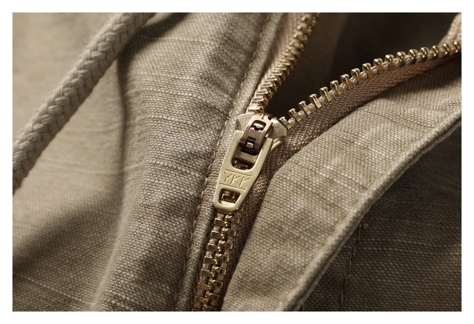 Macro view of a gold-tone zipper on taupe shorts, with YKK stamped on the pull.