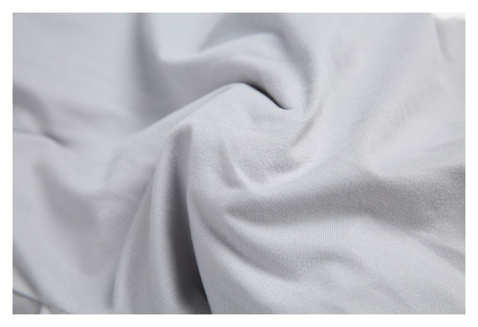 Close-up of the light gray trouser fabric and its folds.
