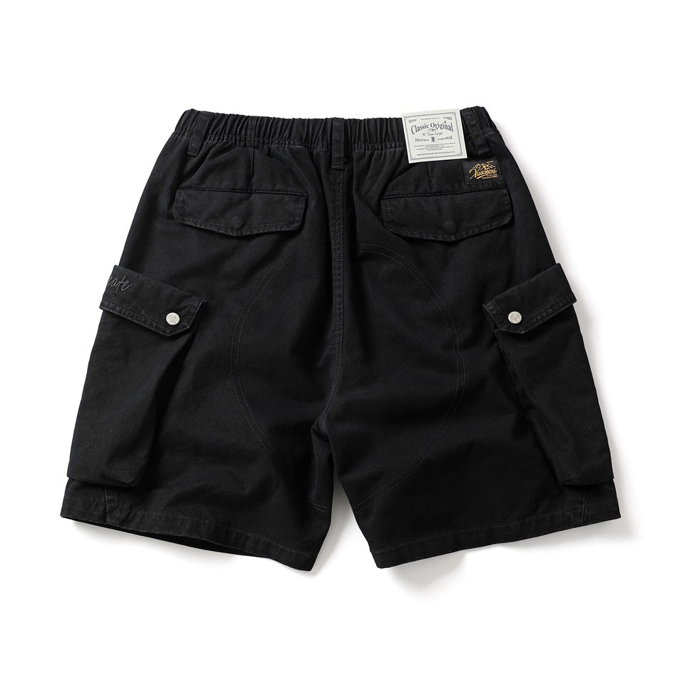 Back view of black cargo shorts with an elastic waist, two flap pockets, and large snap-button side pockets.