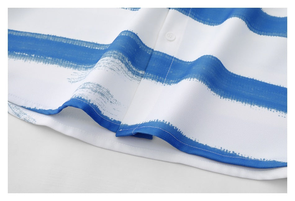 Close-up of the shirt's curved lower hem and button placket with blue brushstroke stripes.