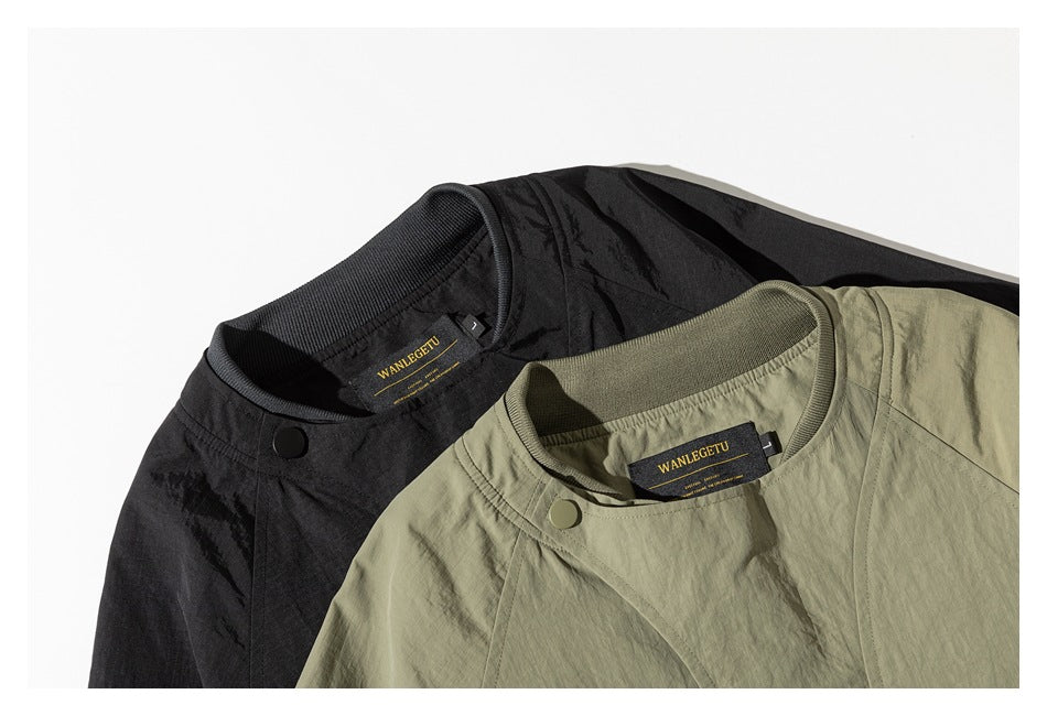 Close-up of olive and black jacket collars, snap fasteners, and sewn neck labels.