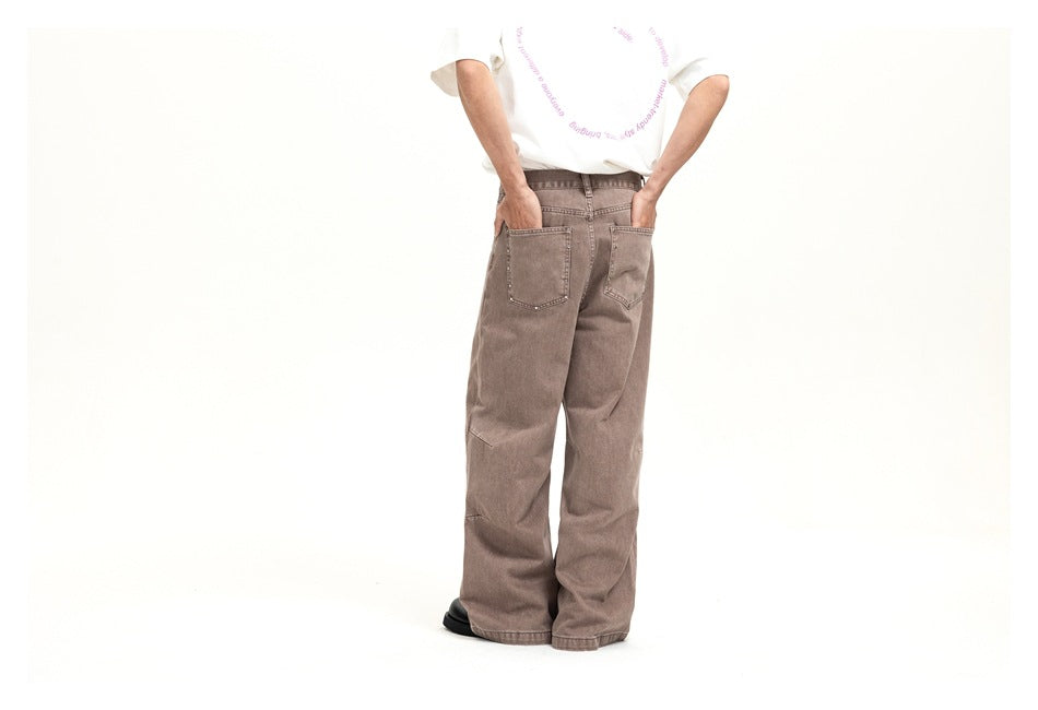 Rear view of a model wearing taupe wide-leg jeans with two large back pockets; the white T-shirt has pink lettering.