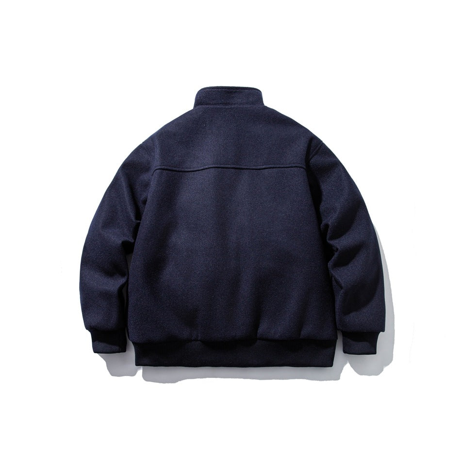 Back view of a dark navy jacket with a stand collar, long sleeves, and ribbed cuffs and hem.
