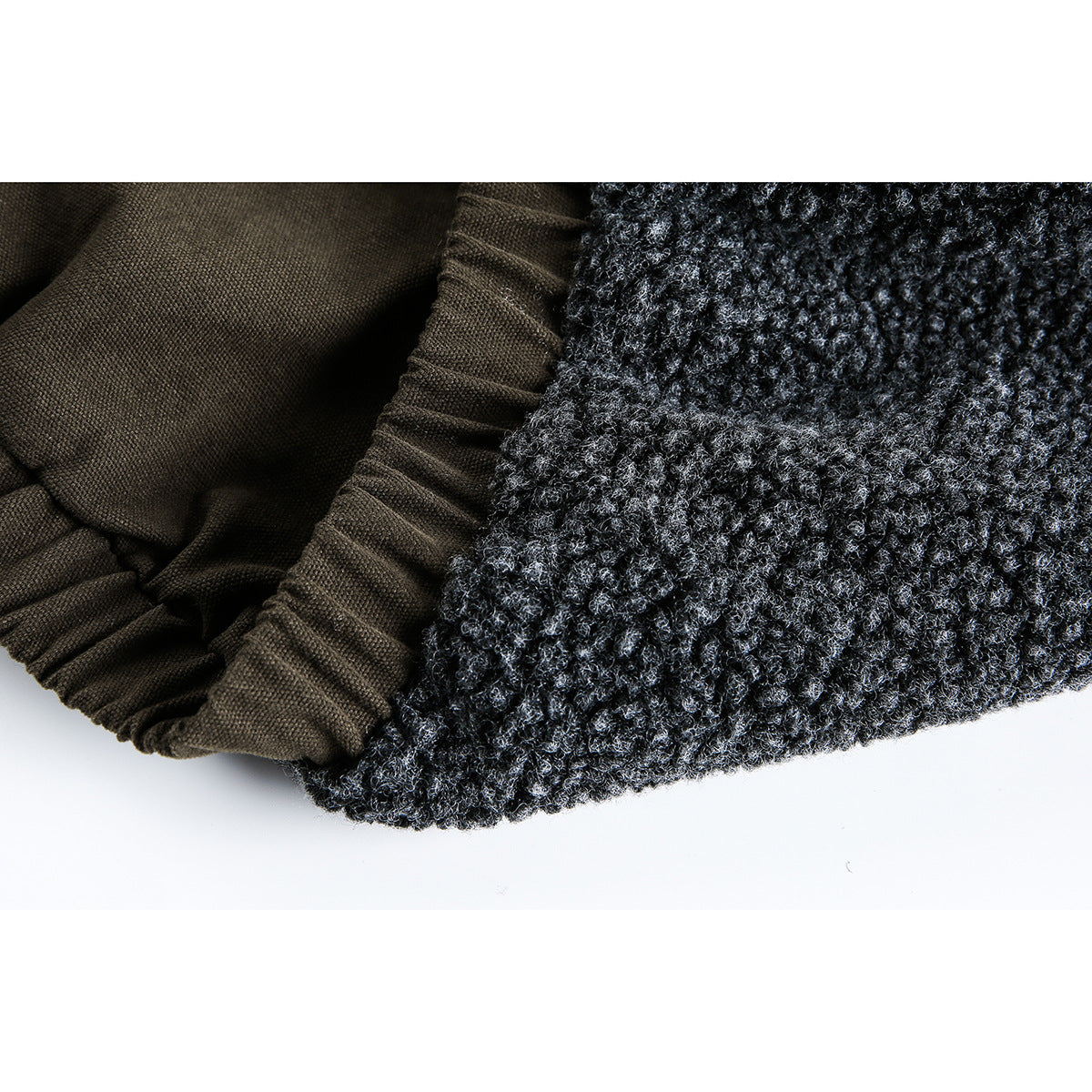 Close-up of the jacket's charcoal textured fabric and gathered dark lining at the edge.
