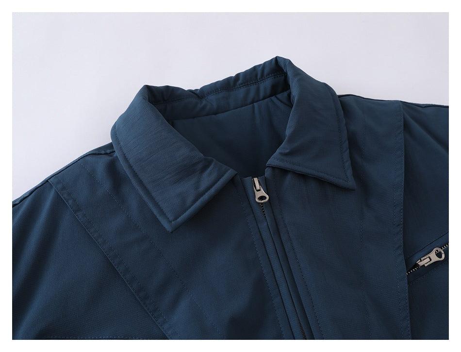 Close-up of a dark navy jacket collar and front zipper, with stitched panels and a partly visible zip pocket.