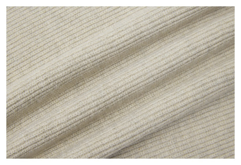 Macro view of the cream garment's narrow ribbed knit texture.