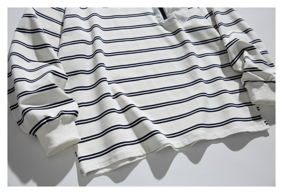 Flat-lay front view of an off-white long-sleeve top with navy horizontal stripes and ribbed cuffs.