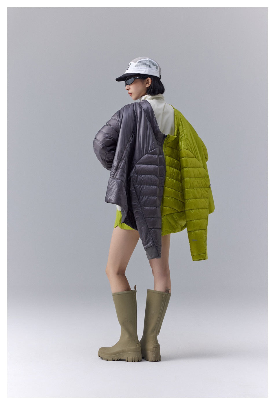 Model in a lime and charcoal quilted jacket, shown from the back and side with olive knee-high boots.