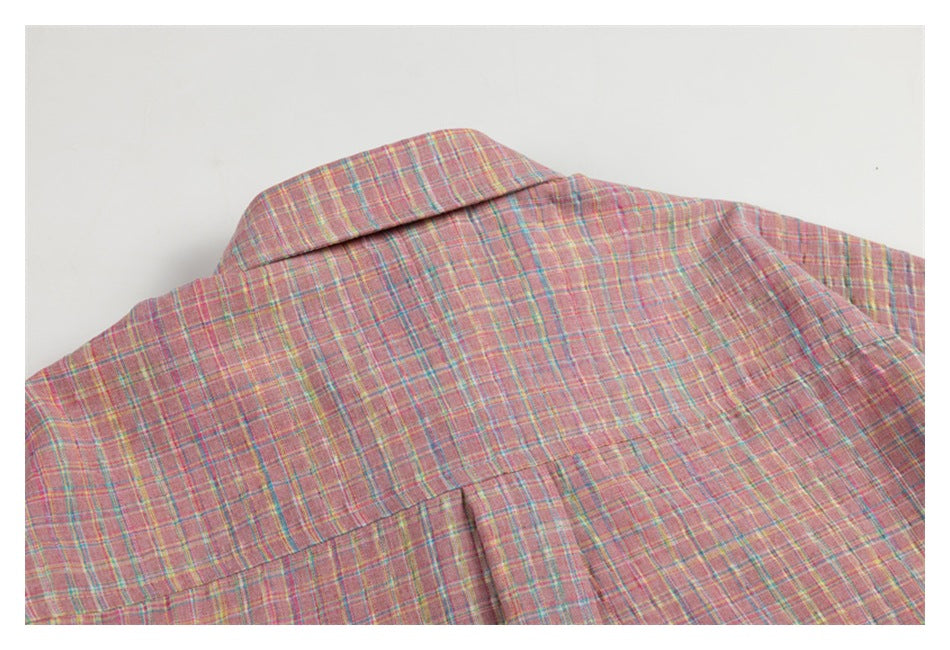 Close-up of the collar, back yoke, and pleat of a pink plaid shirt.