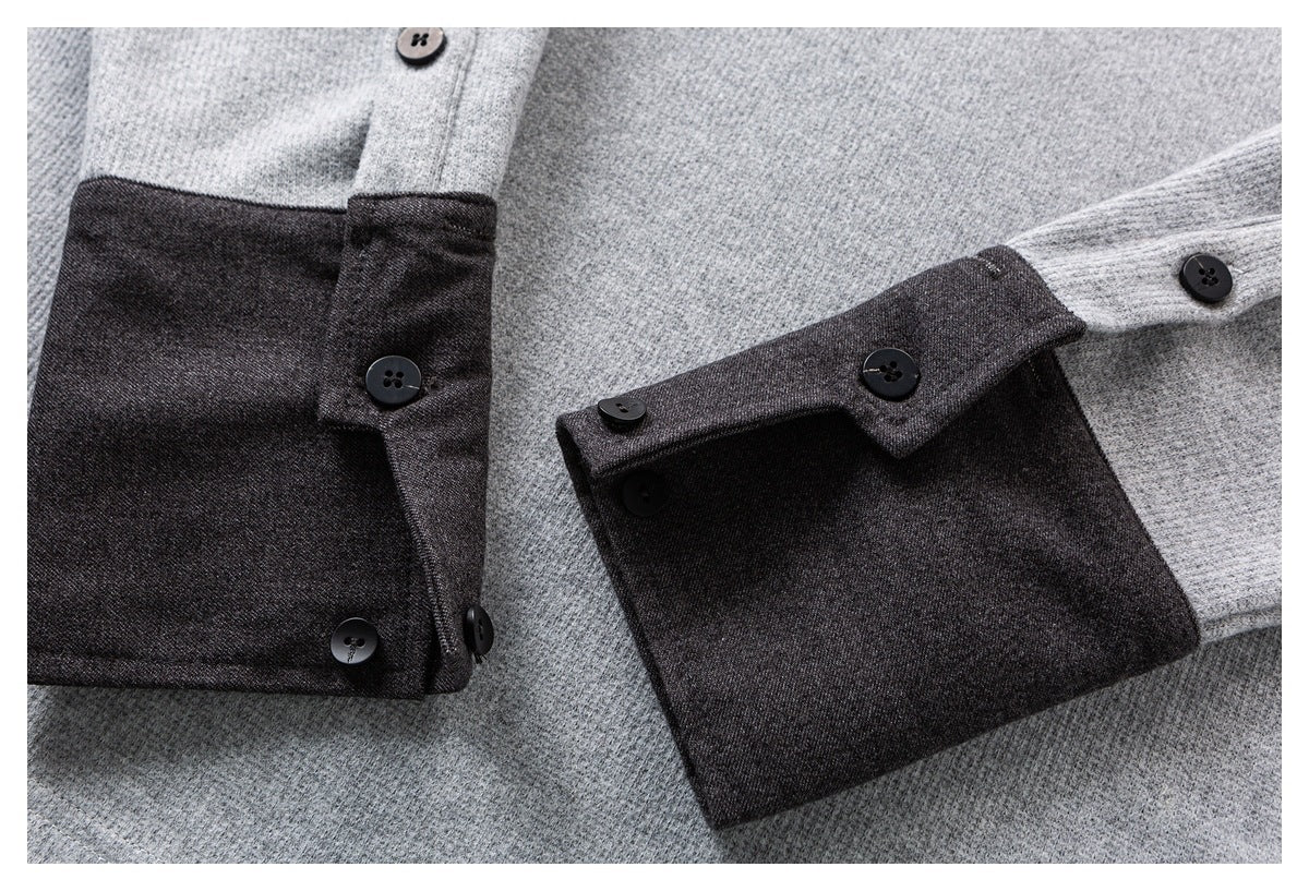 Close-up of gray shirt sleeves with dark charcoal cuffs and black buttons.