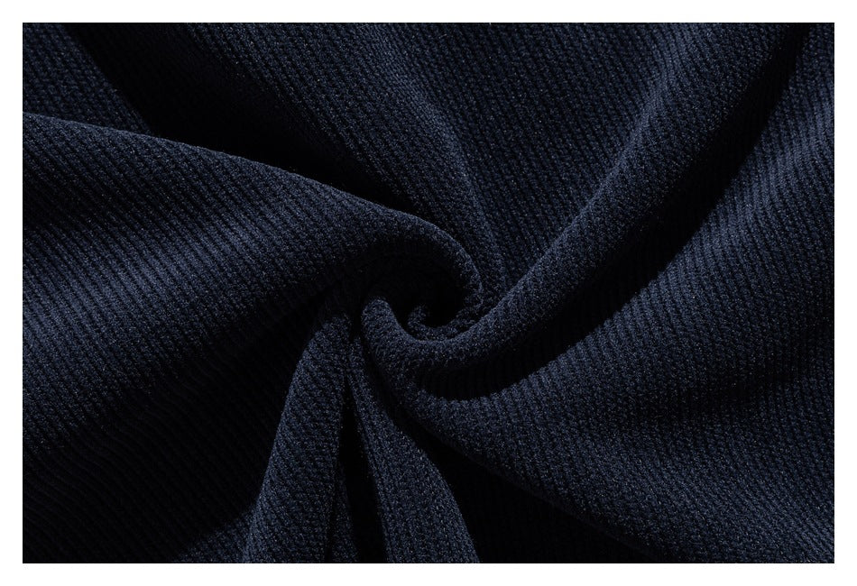 Close-up of dark navy ribbed fabric gathered into folds, showing its textured surface.
