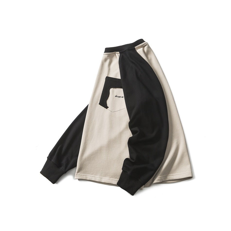 Angled front view of a cream sweatshirt with black raglan sleeves and a contrast chest pocket, arranged flat.