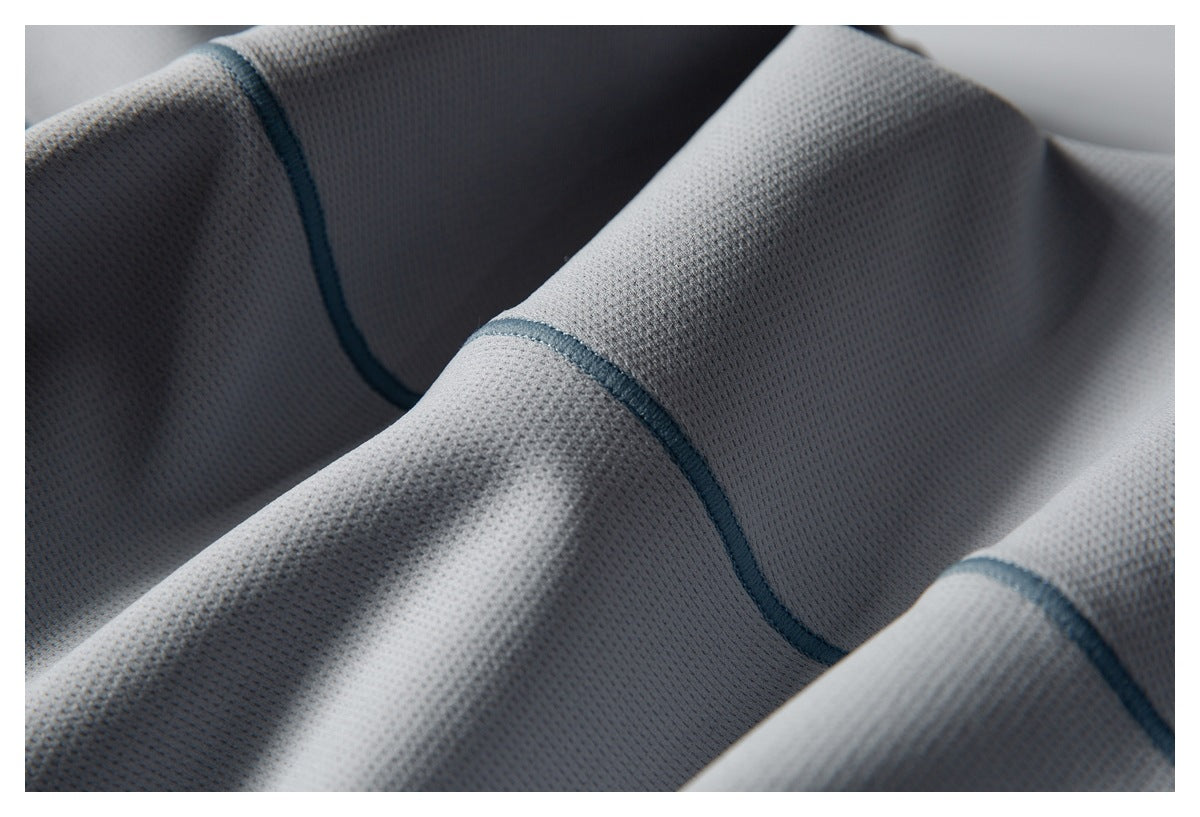 Close-up of light gray mesh fabric with contrasting blue seam stitching.