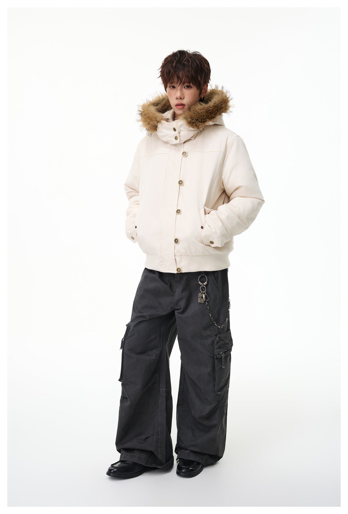 Full-length model wearing an ivory fur-trimmed hooded jacket with dark cargo trousers.