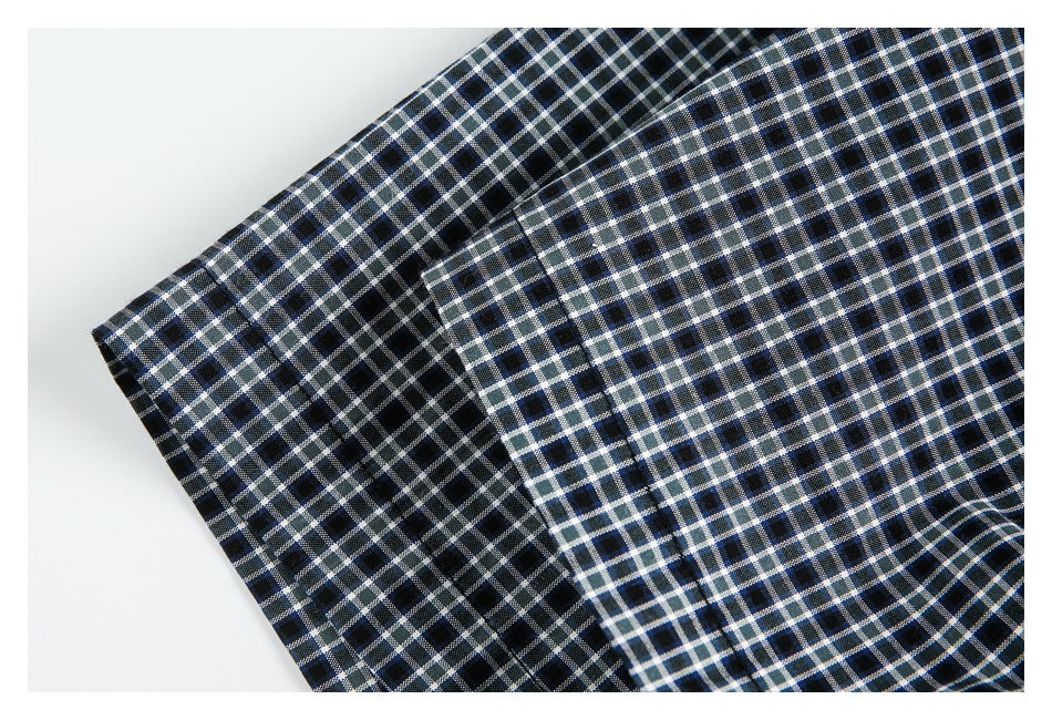 Close-up of the checked shirt's cuff and sleeve stitching.