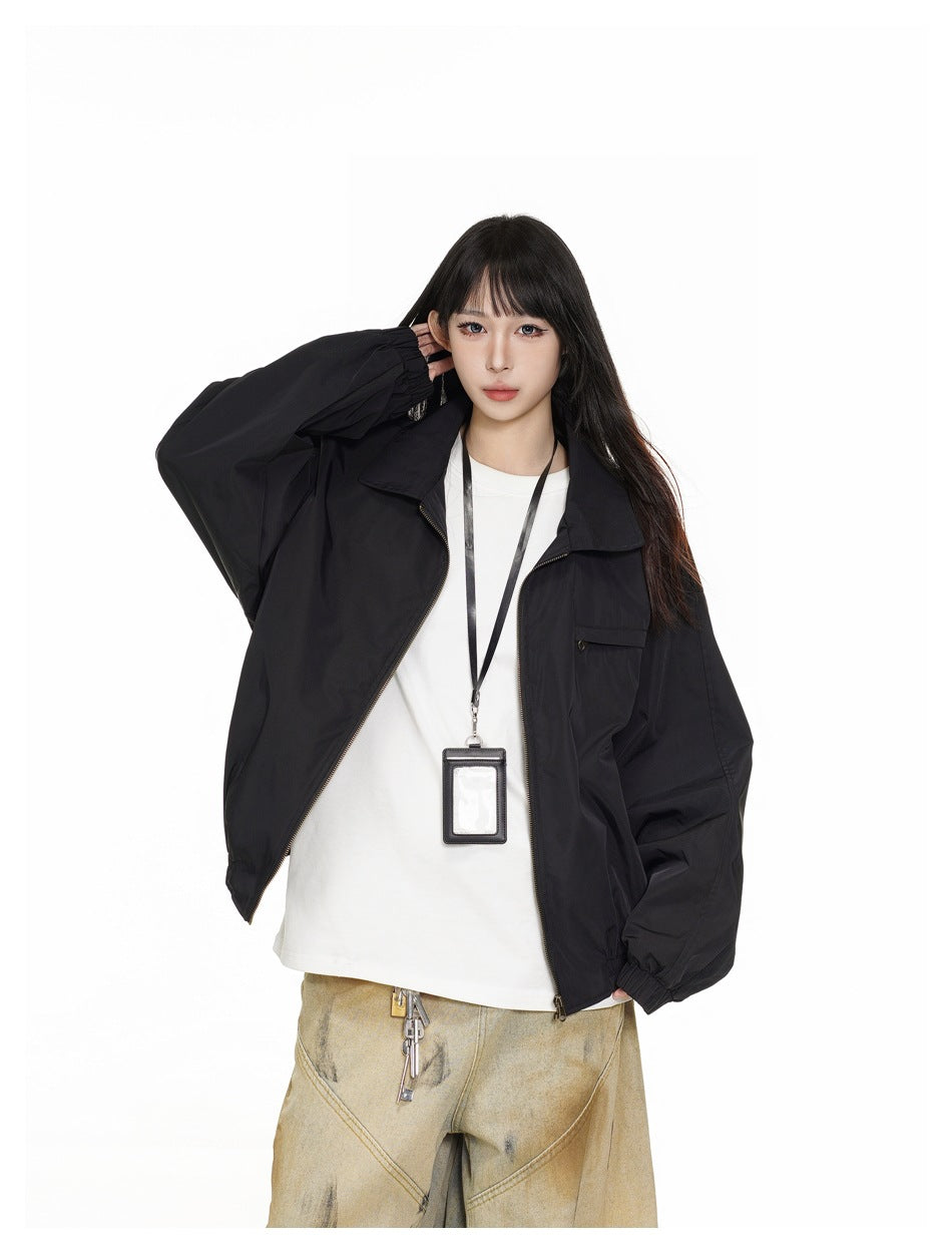 Close view of a model wearing an open black zip jacket with a wide collar and flap chest pocket.