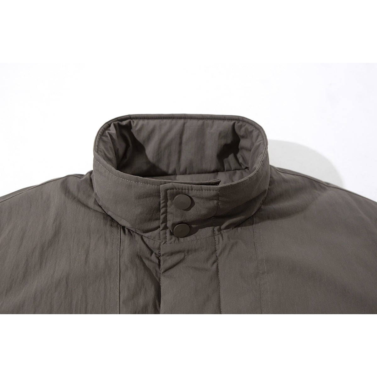 Close-up of a charcoal gray jacket's stand collar, snap-button throat tab, and front stitching.