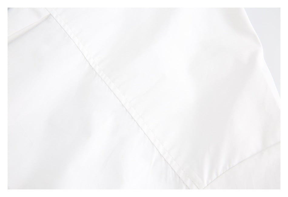 Close-up of white fabric with a diagonal stitched seam and folded edges.