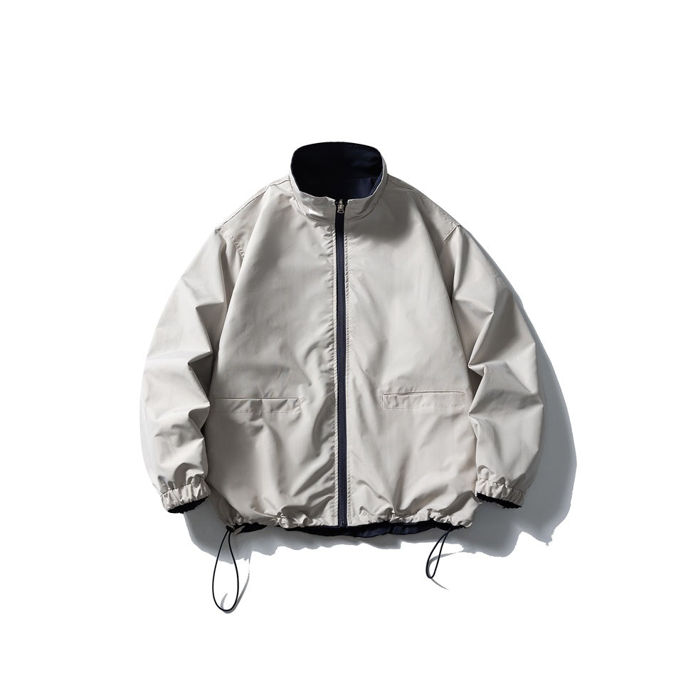 Front view of a light gray zip-front jacket with a stand collar, slanted pockets, elastic cuffs, and adjustable hem cords.